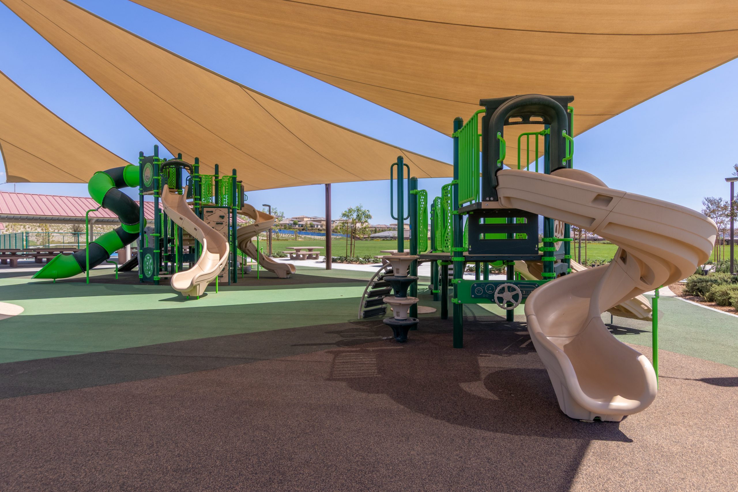 Close-up view of two shaded play structures featured in Pacific Play Systems’ commercial playground installation at Fairway Canyon Park.