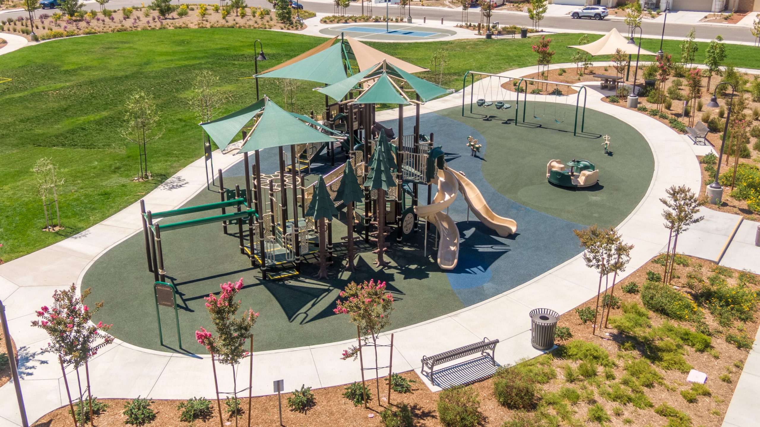 Classic swings at La Pradera South Park in Winchester, CA, designed as part of the forest-themed playground by Pacific Play Systems.
