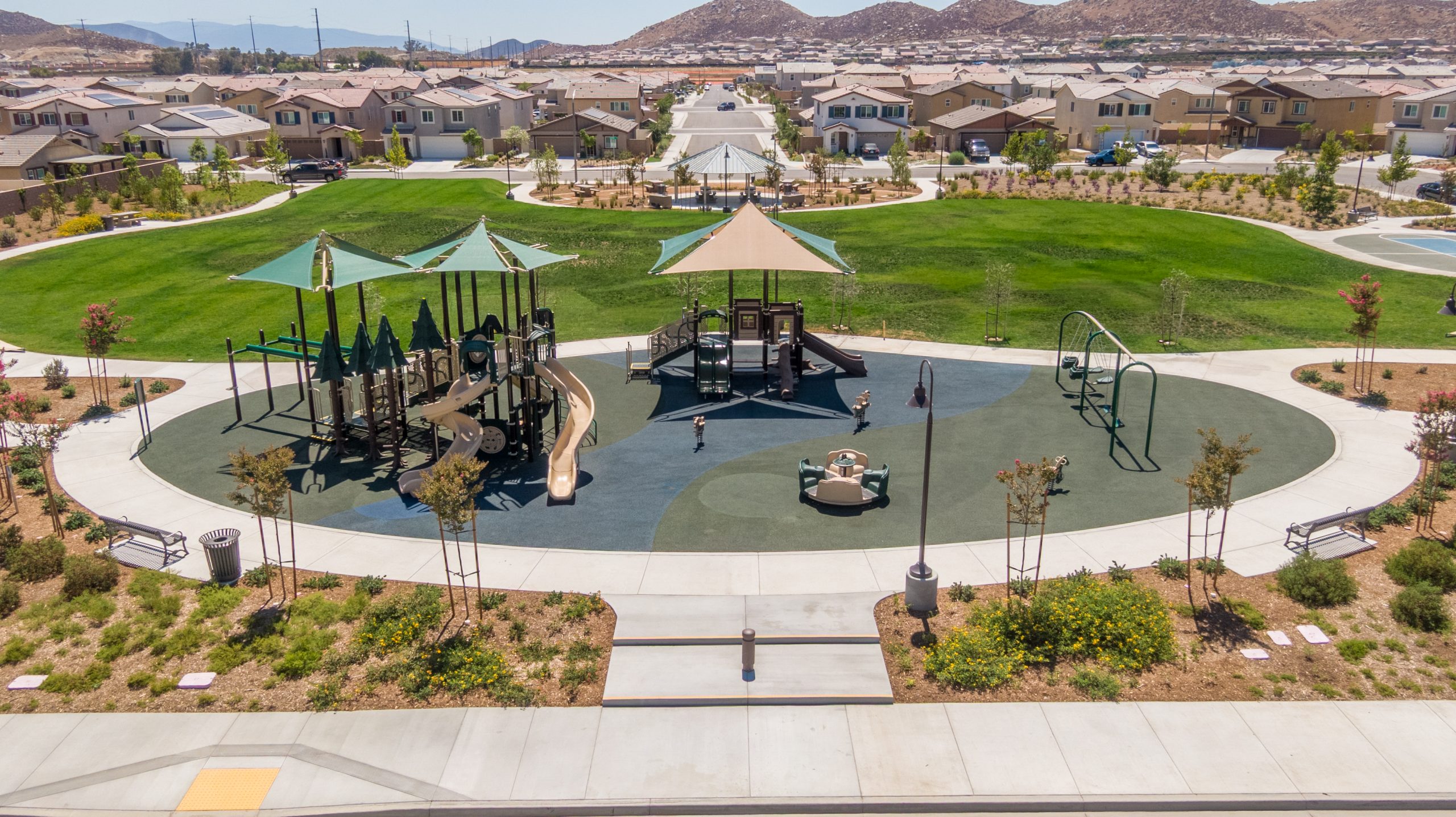 La Pradera South Park playground in Winchester, CA featuring brown and forest green play structures, slides, swings, spinners, and safe PIP surfacing