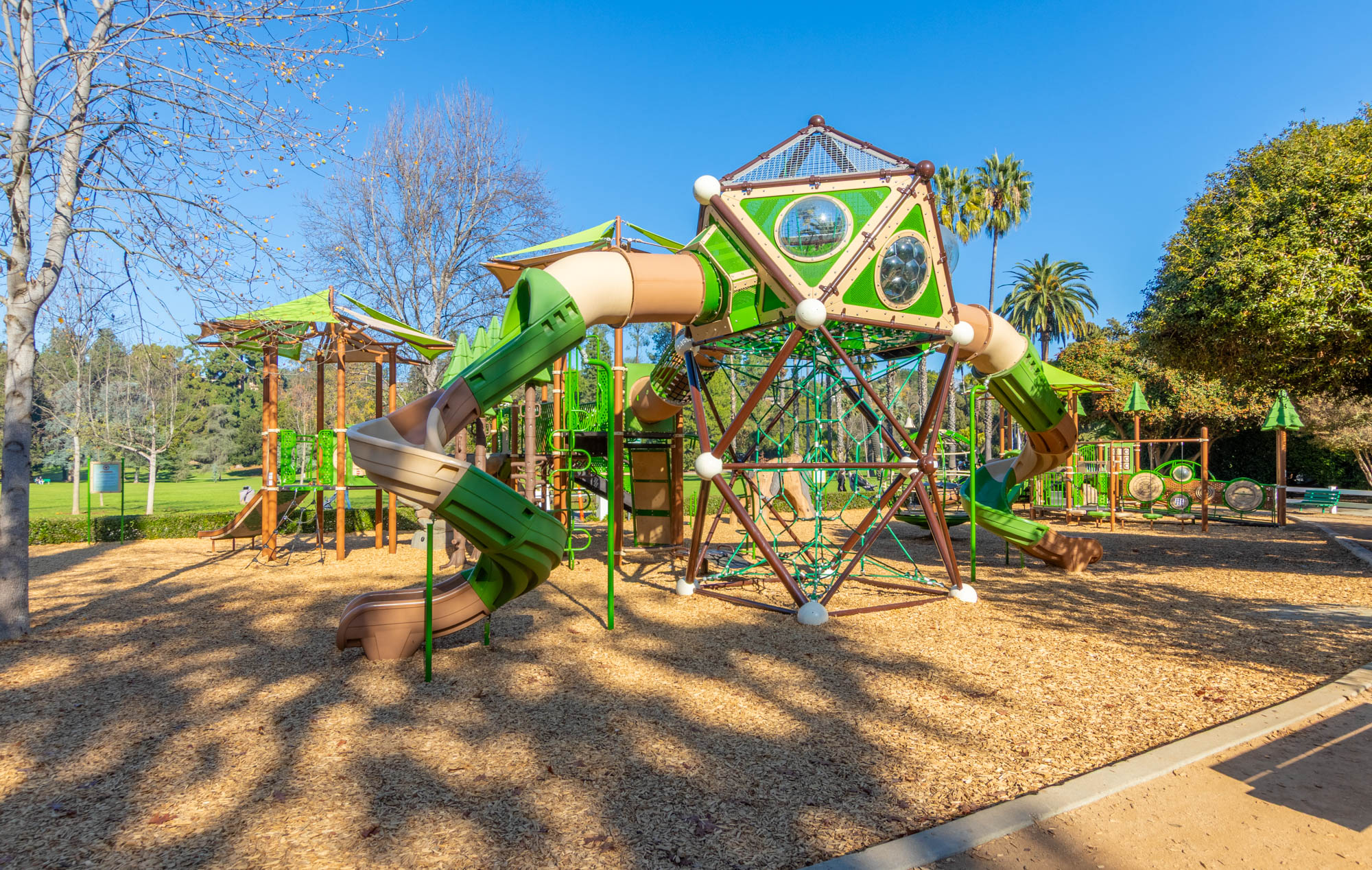 5–12 playground at Lacy Park in San Marino with multiple slides, climbers, shade structures, and nature-themed accents